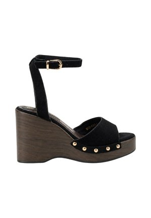 Sandalia cuña de ante negro con plataforma de madera, correa en el tobillo con hebilla dorada, puntera abierta y tachuelas doradas a lo largo del borde de la suela.