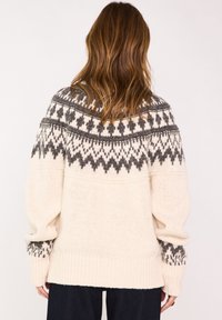 Maglione lavorato a maglia crema con un motivo geometrico grigio scuro sulla zona delle spalle e sui polsini, dal taglio rilassato e con orlo a coste.