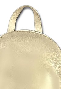 Ronde crèmekleurige leren tas met een soepele textuur, voorzien van korte handvaten en gestikte randen, met een minimalistisch ontwerp.