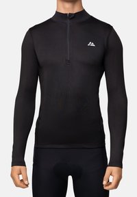 Jersey de ciclismo negro de manga larga con cremallera frontal de un cuarto y pequeño logotipo blanco en el lado izquierdo del pecho, combinado con pantalones cortos de ciclismo negros acolchados.