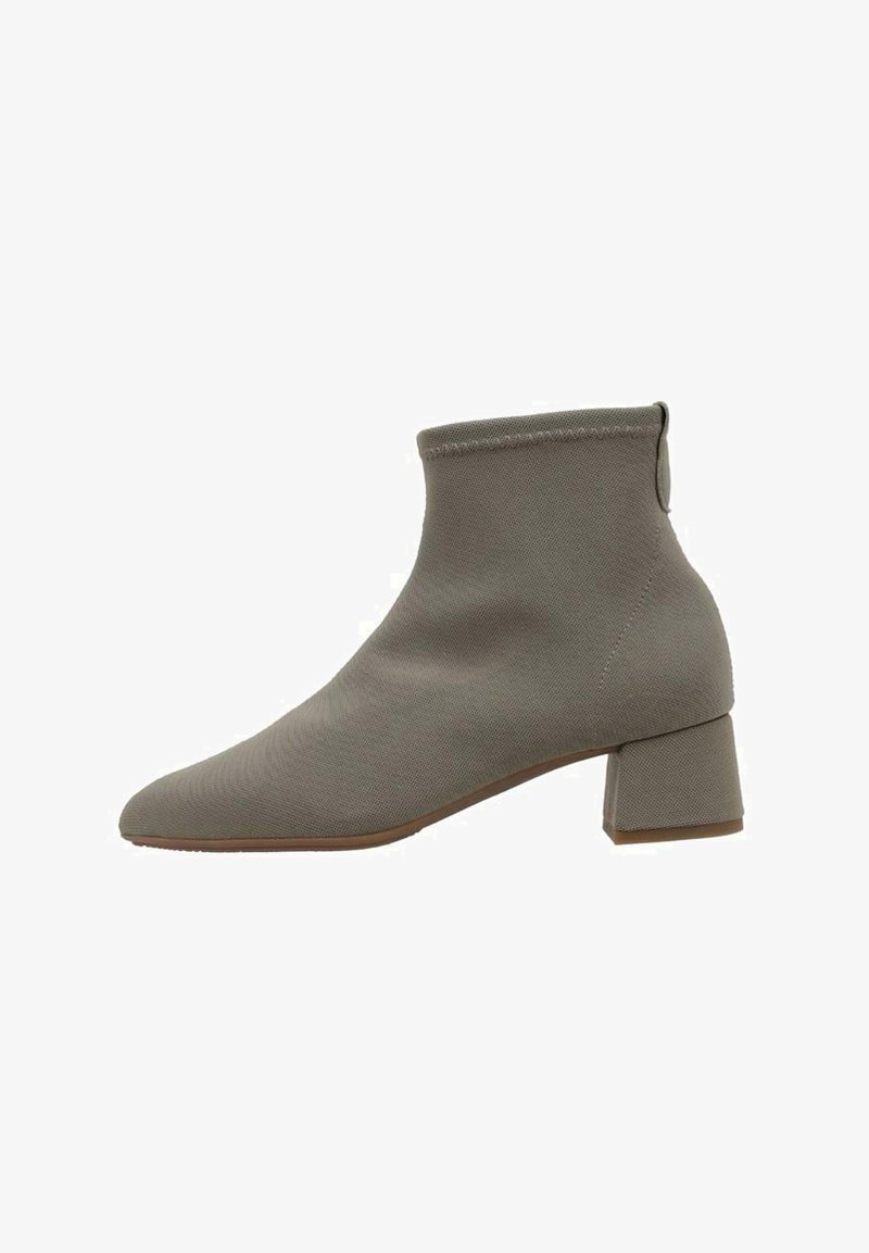 Bottine grise en tissu texturé, dotée d'un bout pointu et d'un talon carré. Design simple avec une structure minimaliste.