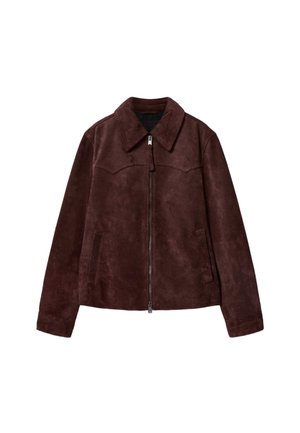 Ruskea mokkatakki, jossa on etuvetoketju, leveä kaulus, pitkät hihat ja kaksi pystysuoraa halkiopussia kummallakin puolella.