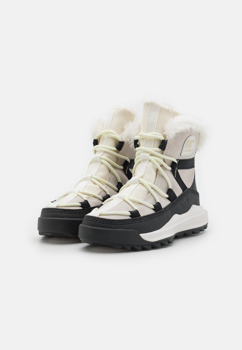 Knöchelhohe Winterstiefel in Creme und Schwarz, mit weichem Kunstfell, auffälligen Schnürsenkeln, einer strukturierten Sohle und einem besonderen Design für besseren Halt.