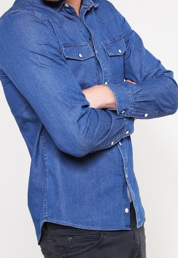 Džínová košile v tmavě modré barvě, dlouhé rukávy, zapínání na knoflíky vpředu, dvě náprsní kapsy s klopami a kontrastní šití podél švů.