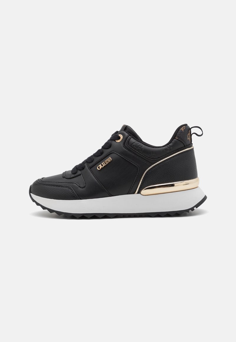 Baskets de sport noires avec un dessus en cuir texturé, accents dorés, col rembourré et semelle en caoutchouc blanc avec un motif de relief en zigzag.