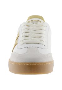 Vit avslappnad sneaker med beige detaljer, tjock gummisula och vita snören, sett framifrån.