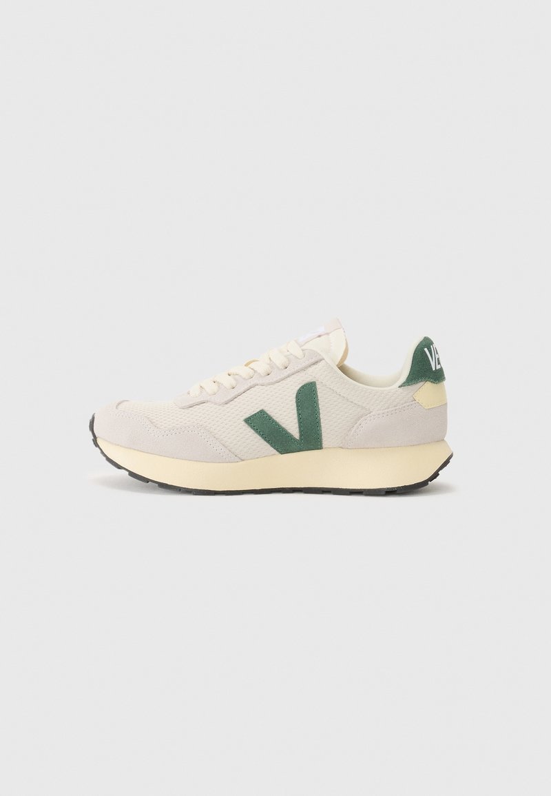 Baskets basses beige et crème avec un logo "V" vert sur le côté, une languette de talon verte marquée "VEJA" et une semelle en caoutchouc noire.