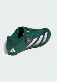 Green athletic shoe with textured upper, white stripes, and circular BOA tightening dial. Features a snug fit for performance.