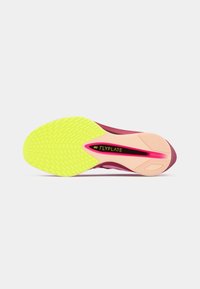 Nike Flyplate sko såle har en unik gul gummisåle med teksturert grep, rosa detaljer og et elegant design i nyanser av mørkerød.