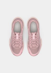 Ζευγάρι ροζ αθλητικά παπούτσια ASICS με ύφασμα από δίχτυ και κορδόνια, σελφονομένο από πάνω σε μονόχρωμο λευκό φόντο.