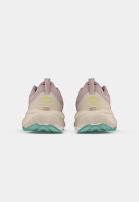 Jasno-beżowe buty biegowe z różowymi akcentami i miętową podeszwą, z teksturowanym wzorem i pętelką na pięcie ułatwiającą zakładanie.