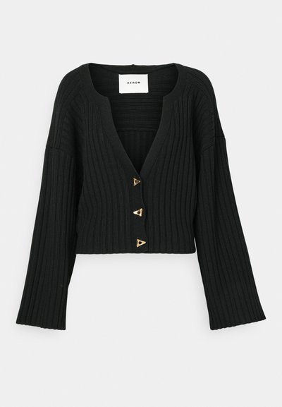 Cardigan preto cropped feito de tecido canelado, apresentando um decote em V profundo, três botões triangulares dourados e mangas largas.