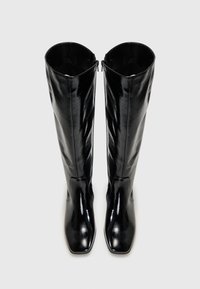 Botas pretas até ao joelho, feitas de um material brilhante, com biqueira quadrada e fecho de zip na parte de trás. Textura lisa sem padrões visíveis.