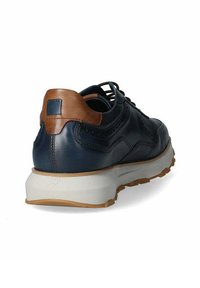 Sneaker in pelle blu scuro con dettaglio in pelle marrone sul tallone, suola intermedia bianca e suola in gomma testurizzata. La vista posteriore mostra il design con lacci.