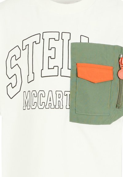 Tessuto bianco con testo delineato in nero "STEL" e "MCCART" parzialmente visibili, caratterizzato da una tasca in tessuto verde e arancione con dettaglio della cerniera.