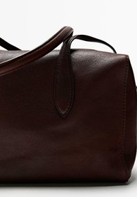 Borsa a mano in pelle marrone con texture liscia, forma arrotondata, manici corti e cuciture decorative. Presenta un leggero motivo a grana.