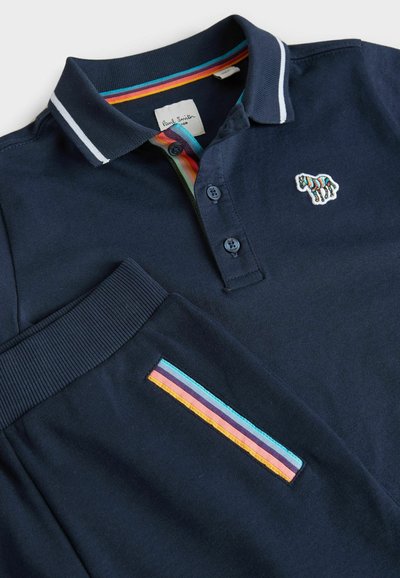 Námornícke polo tričko s pruhovaným golierom, so malým vyšitým logom zvieratka a akcentom vrecka s viacfarebnými pruhmi.
