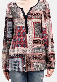 Blusa de patchwork multicolor con escote en V, mangas largas y una botonera negra; fabricada en un tejido ligero con distintos patrones.