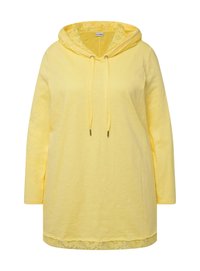 Žlutá kapucínová tunika s dlouhým rukávem a krajkovým lemem na spodním okraji. Obsahuje stahovací kapuci a volný střih. Vyrobena z lehkého materiálu.