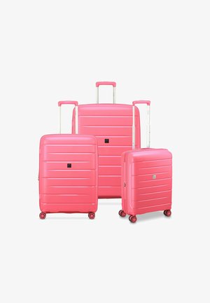 Drei pinke Hartschalenkoffer in unterschiedlichen Größen mit Rillendesign, ausziehbaren Griffen und jeweils vier Rollen für Mobilität.