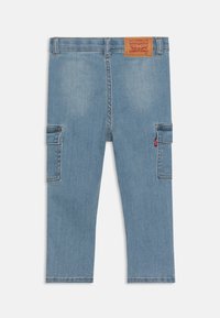 Pantalons cargo en denim bleu clair avec deux poches latérales, des détails de couture et une étiquette en cuir à la taille portant le logo Levi's.