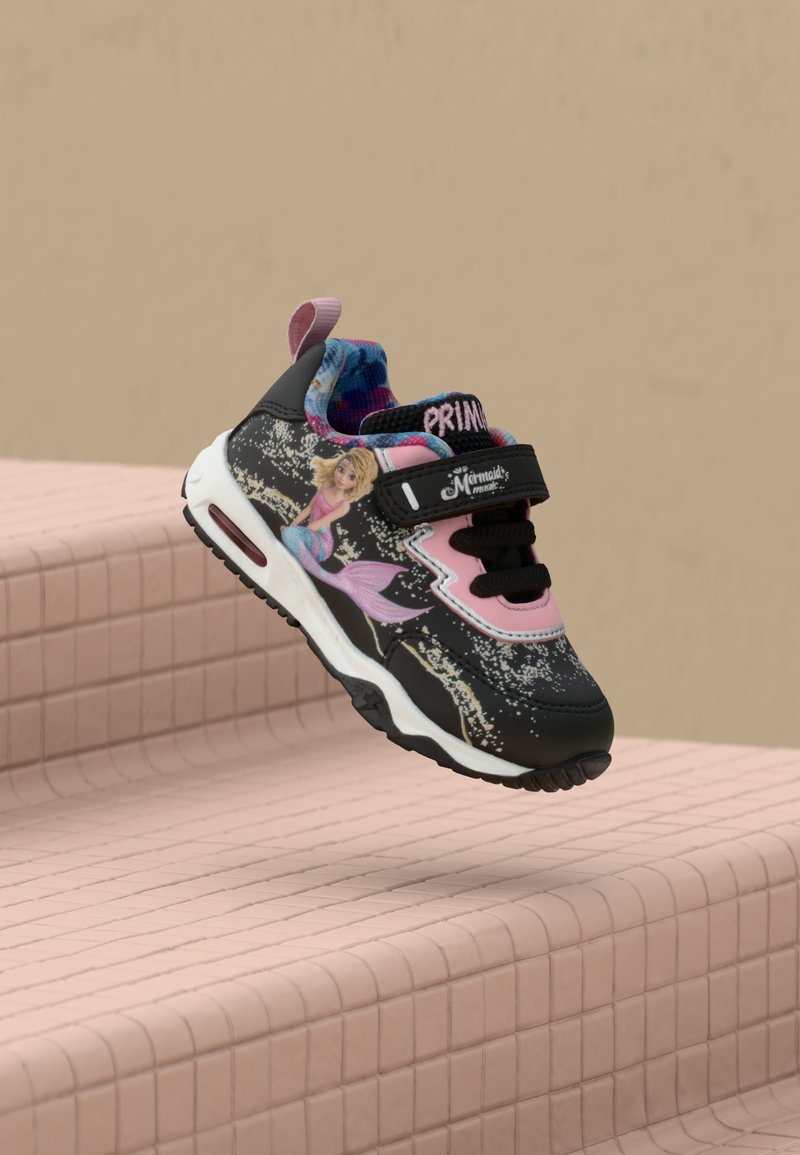 Svart og rosa barne-sneaker med mermaid-grafikk, glitrende detaljer, borrelåsstropp og mønstret blå-rosa innersåle, på flislagte rosa trapper.