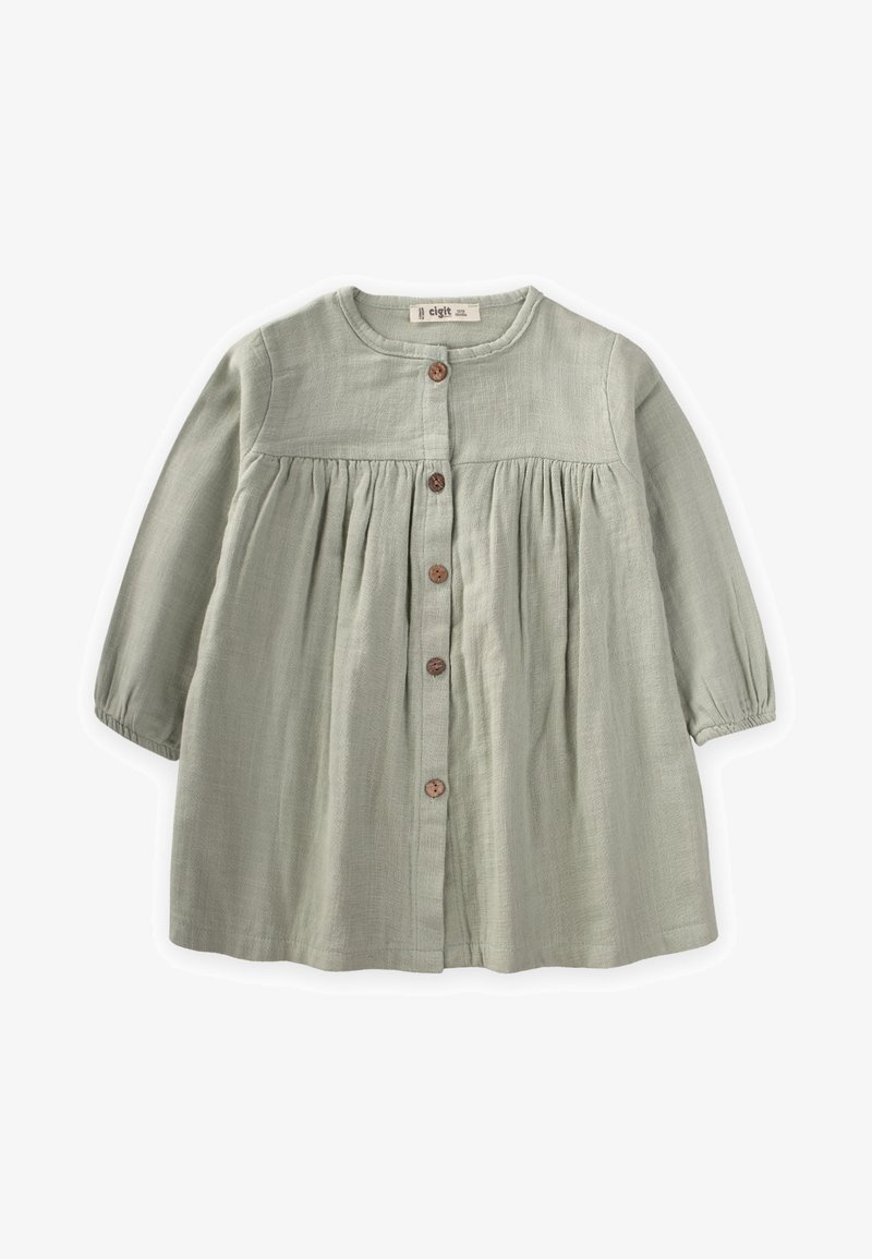 Svijetlozelena haljina dugih rukava s okruglim izrezom, zatvaranjem na gumbe sprijeda i nabrane strukom. Izrađena od teksturirane tkanine s drvenim gumbima.