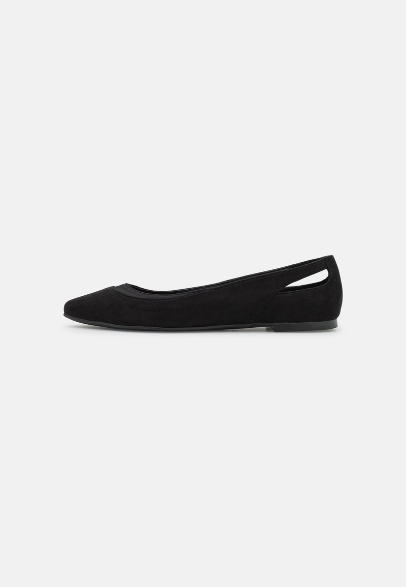 Chaussure plate en daim noir avec une pointe effilée et une découpe ouverte à l'arrière, vue de côté sur fond blanc.