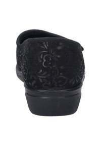 Sort stof slip-on sko med et blomsterpræget mønster, afrundet bag, lav hæl og struktureret overflade.