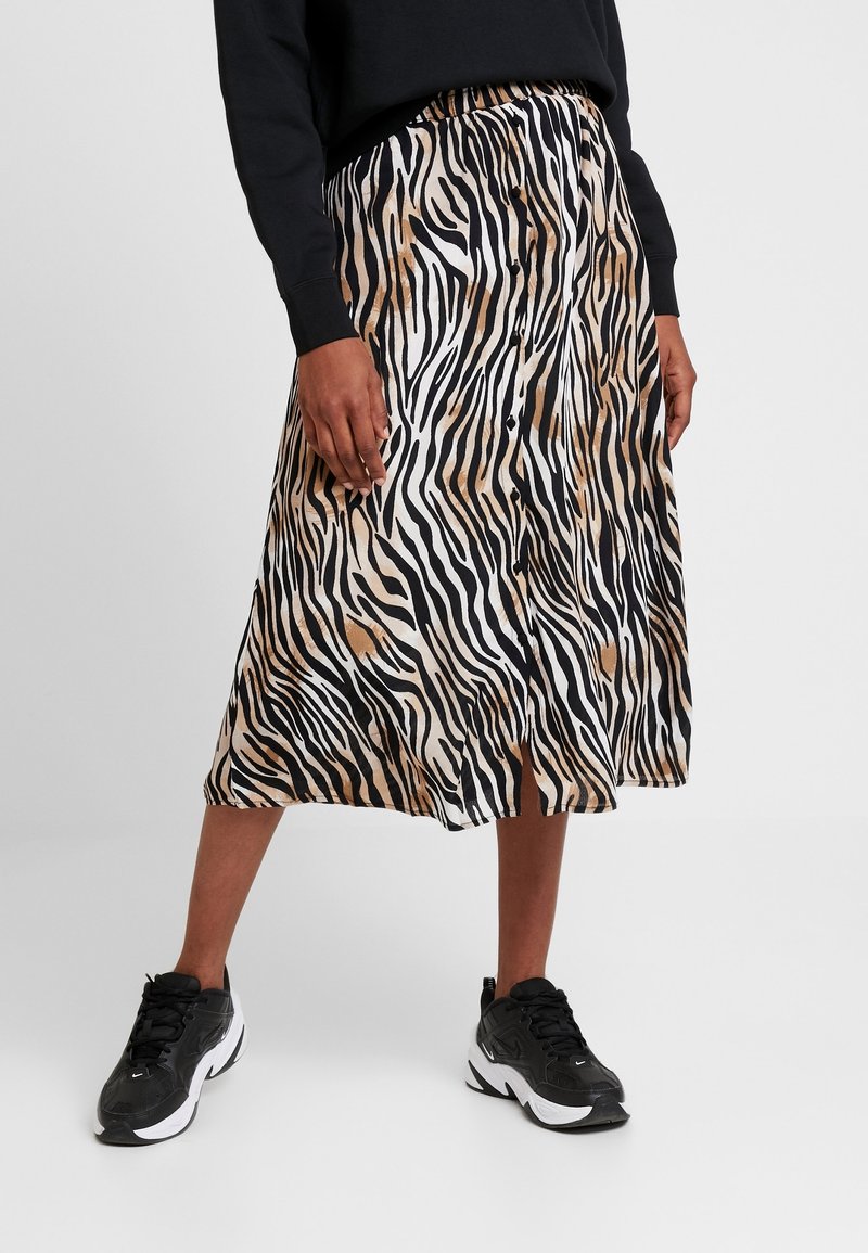 Jupe midi zébrée en beige, noir et blanc, fabriquée en tissu léger avec une taille élastique et une fermeture à boutons à l'avant.