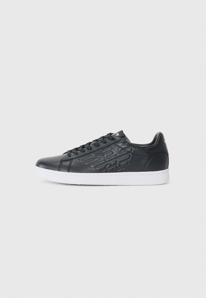 Sneaker din piele neagră cu design embosat, vârf rotund și talpă din cauciuc alb. Dispune de sistem de închidere cu șireturi și branding pe limbă și călcâi.