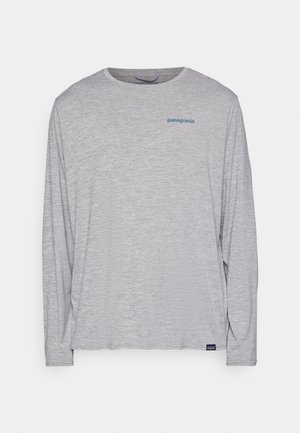 T-shirt à manches longues gris clair en tissu doux et texturé. Il présente un col rond et un petit logo Patagonia bleu sur la poitrine.