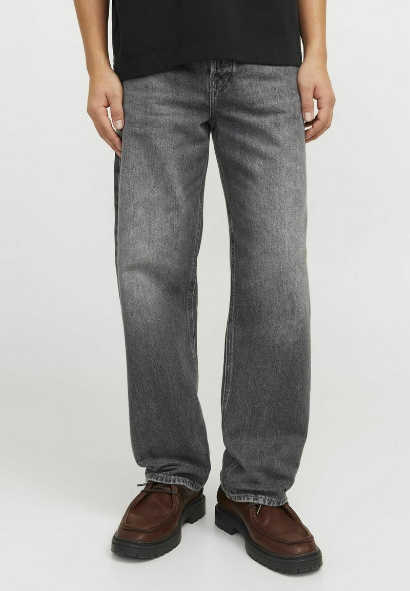 Grå raka jeans i denim med en blekt tvätt, femficksdesign och sömdetaljer. Bärs med bruna skor.