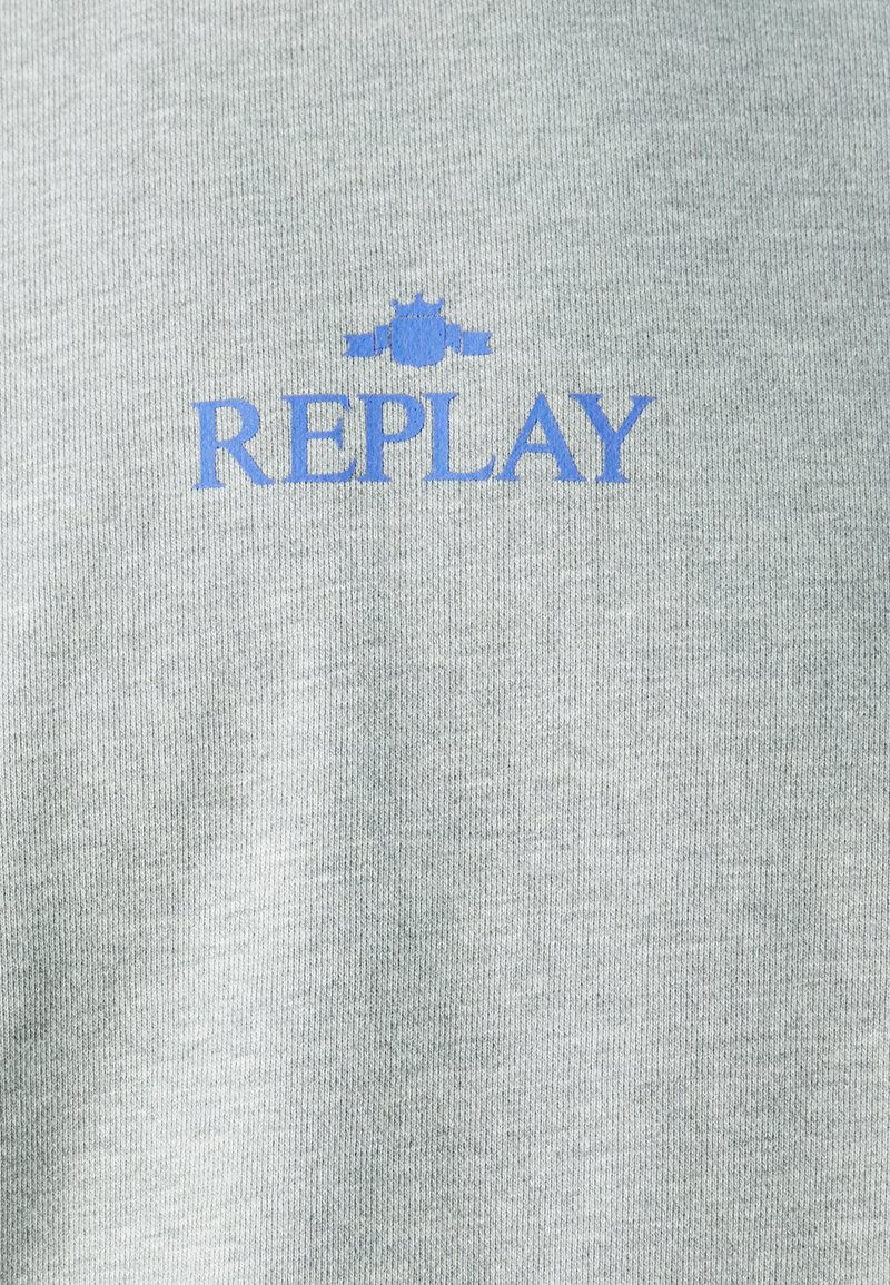 Sudadera gris con textura acanalada que presenta un logo azul de "REPLAY" y un emblema encima del texto.