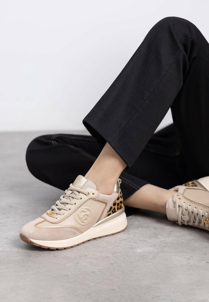 Zapatillas beige de ante y tejido con un acento de estampado de leopardo. Diseño con cordones y detalle del logo, y suela texturizada.