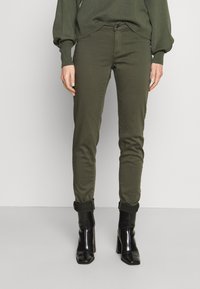 Olivgröna slim fit byxor med smal passform, uppvikta benslut och frontknappsstängning. Tillverkade av ett mjukt, stretchigt material.