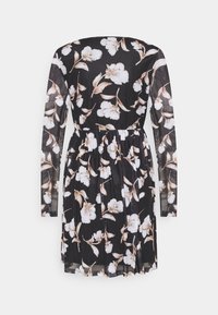 Robe longue à manches longues noire avec des fleurs blanches et beiges, taille légèrement froncée, et tissu doux et transparent.