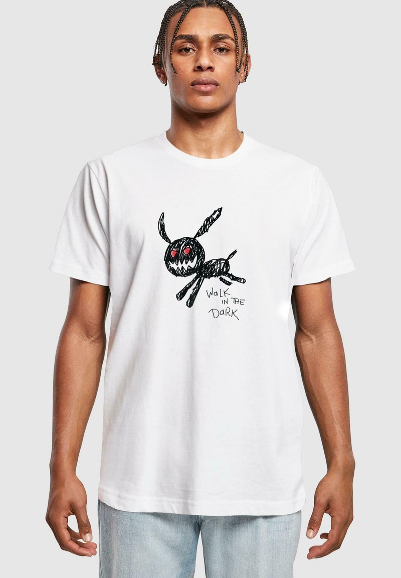 Hvid bomulds t-shirt med en sort tegneseriefigur med røde øjne og teksten "WALK IN THE DARK" i en legesyg, skitse-lignende stil.