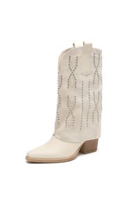 Bota de vaquero beige con punta afilada, parte superior de ante, tachuelas decorativas plateadas, abertura en ángulo y tacón cuadrado.