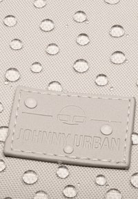 Water-resistant gray fabric with textured surface, featuring clear water droplets. Includes embossed tag with "JOHNNY URBAN" branding.