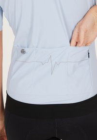 Lichtblauw sportshirt met een ontwerp van een hartslaglijn, voorzien van een achterzak en een zwarte elastische taille. Glad oppervlak en slim fit ontwerp.