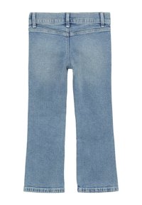 Jasnoniebieskie dżinsy z rozszerzającymi się nogawkami, pięcioma kieszeniami i szlufkami na pasek. Materiał jest miękki i ma lekko postarzany wygląd.