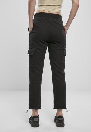 Svarte cargo joggebukser med sidelommer, tapered ben og glidelåsdetaljer ved anklene. Belte er elastisk for komfort. Materialet er mykt.