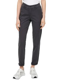 Mörkgrå byxor med slim fit, knappstängning, uppvikta fållar och framfickor, tillsammans med vita sneakers med nätstruktur.