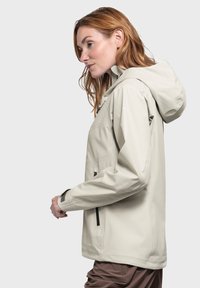 Helle beige, wasserdichte Jacke mit Kapuze, Reißverschluss vorne und Taschen sowie verstellbaren Manschetten. Glatte Textur mit minimalistischer Gestaltung.