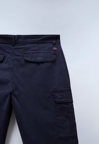 Marineblauwe cargobroek met achterklepzakken en een klein Noors vlaggenpatch op het rechterzakgebied.