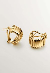 Aretes de aro dorados con un diseño acanalado, que presentan una textura metálica suave y un cierre de clip. Muestran un acabado pulido y brillante.
