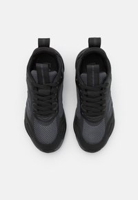 Svarta och gråa träningsskor med nät- och syntetmaterial, med rund tå, snörningsdesign och dragflik på hälen.