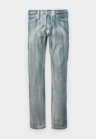 Jeans de ganga azul com corte reto, apresentando um acabamento desbotado, cinco bolsos e detalhes em metal cobre na cintura.