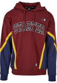 Sweat à capuche bordeaux avec un grand logo "STARTER" noir, présentant des accents latéraux jaunes et bleus, en coton, avec une poche kangourou.